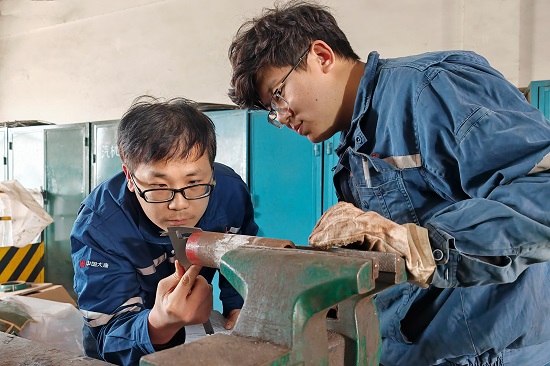 維護部鍋爐專業主管正在檢查指導青工閥門檢修練習要點。 - 副本.jpg